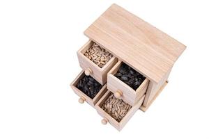 células de caixa de madeira cheias de várias especiarias. caixa de madeira com sementes de girassol, descascadas e cruas foto