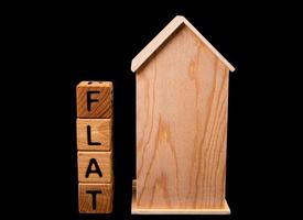 maquete de casa de madeira com chaves de casa, cubos de madeira com venda de aluguel de palavras, compra e empréstimo. em fundo preto foto