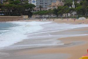 espuma das ondas ao chegarem à areia da praia foto