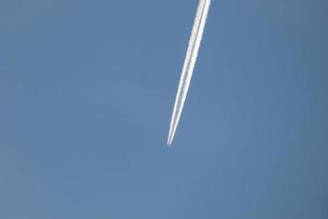 esteira branca de um avião sob o céu azul foto