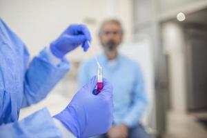 assistência médica segurando covid-19, kit de coleta de swab de coronavírus, usando luvas de máscara de traje de proteção, tubo de ensaio para coleta de amostra de paciente op np, processo de protocolo de teste de dna pcr foto