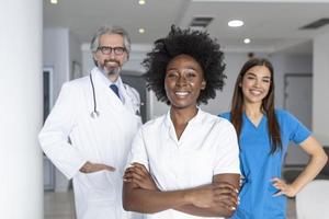 equipe médica sorridente em pé juntos em um conceito de hospital, profissão, pessoas e medicina - grupo de médicos felizes no hospital foto