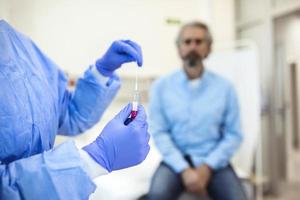 assistência médica segurando covid-19, kit de coleta de swab de coronavírus, usando luvas de máscara de traje de proteção, tubo de ensaio para coleta de amostra de paciente op np, processo de protocolo de teste de dna pcr foto