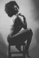 fotografia preto e branco de mulher negra sensual sob luz neon foto