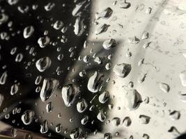 gotas de água na superfície metálica refletindo água e luz. gotas de água. pingos de chuva foto