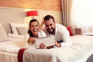 casal feliz descansando no quarto de hotel foto