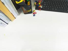 mesa plana e branca no escritório com espaço de layout. com equipamentos de escritório, como lápis, cadernos e teclados no topo. mesa simulada foto