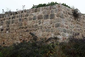 parede de pedra de uma antiga fortaleza à beira-mar em israel. foto