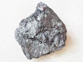 pedra de stibnite de minério de antimônio áspero em branco foto