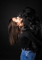 uma garota tem um cachorro labrador retriever nos braços. foto