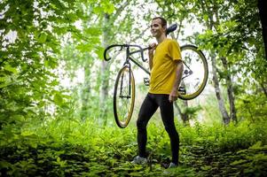 um jovem parou para descansar com sua bicicleta em um parque público. foto