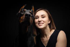 retrato de um cachorro doberman com uma dona de menina. foto