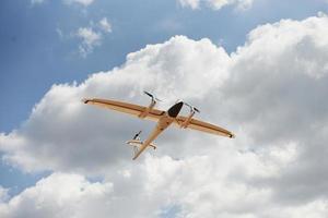 moderno pequeno avião de cor branca controlado remotamente voando no céu foto