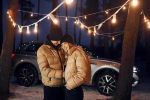 abraçando um ao outro. casal dançando na floresta e comemorando o ano novo foto