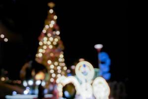 visão turva e bokeh da árvore de natal e decorar a frente de iluminação led do shopping na noite de natal na cidade urbana. foto