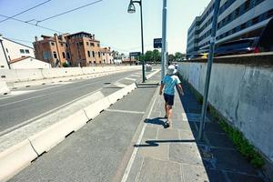 atrás do menino turista andando perto de estacionamento na entrada da cidade de veneza, itália. foto