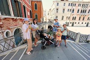 família segurando e bebendo smoothie de coquetel fresco na ponte de veneza, itália. foto