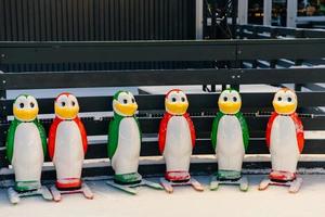 fileira de suportes de skate para alunos de skate, feitos em forma de pinguins coloridos. ajudantes de patinação no gelo. números para iniciantes que estão no gelo pela primeira vez foto