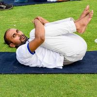 nova delhi, índia, 21 de junho de 2022 - sessão de exercícios de ioga em grupo para pessoas no complexo esportivo yamuna em delhi no dia internacional de ioga, grande grupo de adultos participando de aula de ioga no estádio de críquete foto