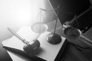 conceito de justiça e direito. juiz masculino em um tribunal com o martelo, trabalhando com, computador e teclado de encaixe, óculos, na mesa na luz da manhã foto