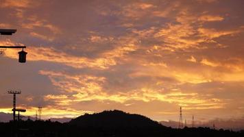 a bela vista do pôr do sol com as nuvens coloridas e a silhueta das montanhas como pano de fundo foto