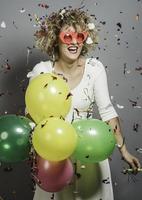 linda mulher comemorando o ano novo com confete e segurando placa. foto