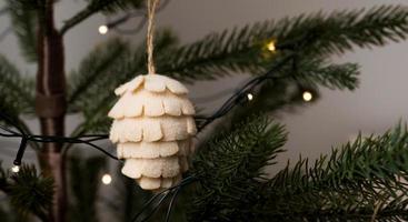 conceito de natal sem desperdício. árvore de natal decorada com enfeites de pinha feitos de materiais naturais. cartão de férias de inverno aconchegante foto