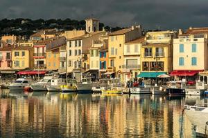 vista panorâmica da pequena aldeia de cassis no sul da frança com reflexo do espelho para o mar mediterrâneo contra o céu dramático foto