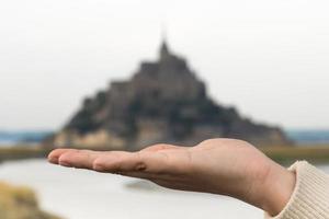 vista panorâmica da mão segurando o monte saint-michel na normandia, frança como um tesouro foto