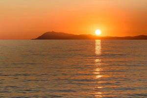 vista panorâmica do globo solar refletida no mar mediterrâneo ao pôr do sol dourado no sul da frança foto