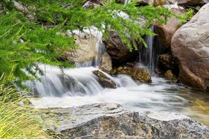 vista panorâmica da cachoeira e rochas no parque nacional mercantour nos alpes franceses durante o dia quente de verão foto