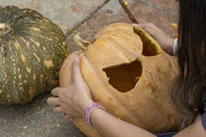 abóbora de halloween esculpida, lanterna de jack, com ferramentas de escultura. riso assustador, cabeça assustadora. foto