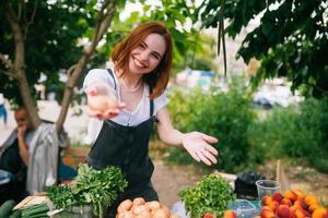 vendedor de mulher no balcão com legumes. conceito de pequena empresa foto