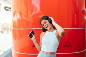 jovem ouvindo música com fones de ouvido sem fio na rua foto