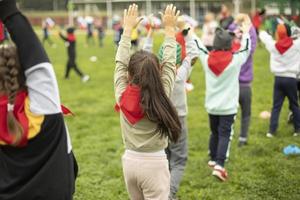 as crianças praticam esportes. criança no lenço vermelho. escoteiros treinam. brincadeira infantil no estádio. foto