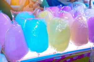 algodão doce colorido com uma variedade de sabores vendidos em frente à loja no festival do templo na tailândia. o algodão doce é feito de açúcar fiado em fios finos semelhantes a nuvens. foto