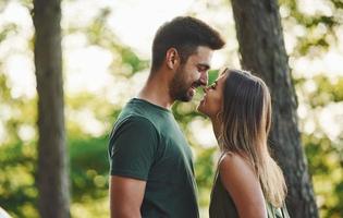 proximidade das pessoas. lindo casal jovem se diverte na floresta durante o dia foto