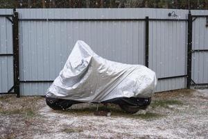 armazenamento de motocicleta sob um toldo no inverno ao ar livre. toldo protetor, sob a neve foto