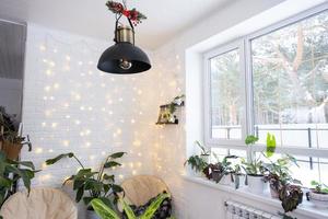 interior de natal de uma casa em estilo loft com um abajur retrô decorado em preto e plantas de interior de strelitzia nicolai. ano novo, conforto em casa foto