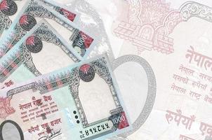 Notas de 1000 rúpias nepalesas encontram-se na pilha no fundo da grande nota semitransparente. fundo abstrato de negócios foto