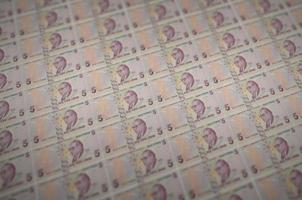 Notas de 5 liras turcas impressas no transportador de produção de dinheiro ilegal. colagem de muitas notas falsas. conceito de trabalho de falsificadores foto