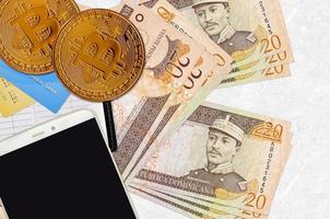 20 notas de peso dominicano e bitcoins dourados com smartphone e cartões de crédito. conceito de investimento em criptomoeda. mineração ou negociação de criptografia foto