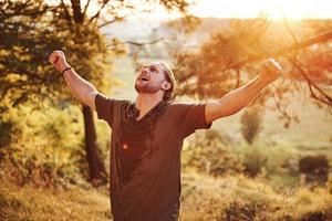 concepção de liberdade. homem bonito na floresta. bom tempo. bela luz do sol cor de laranja foto