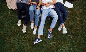 visão de partícula. grupo de jovens estudantes em roupas casuais na grama verde durante o dia foto