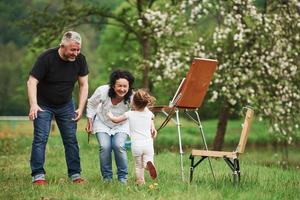 bom Dia. avó e avô se divertem ao ar livre com a neta. concepção de pintura foto