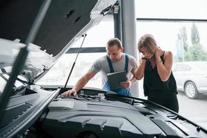 durante o dia. resultados do reparo. homem confiante mostrando que tipo de dano seu carro foi levado foto