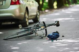 ninguém. bicicleta e acidente de carro prateado na estrada na floresta durante o dia foto