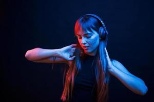 dançar ao ritmo. studio filmado em estúdio escuro com luz neon. retrato de jovem foto