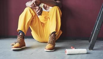 visão fundamentada. jovem trabalhador afro-americano de uniforme amarelo tem algum trabalho foto