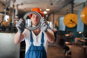 mostra o detalhe que faz do aço. homem de uniforme trabalha na produção. tecnologia industrial moderna foto